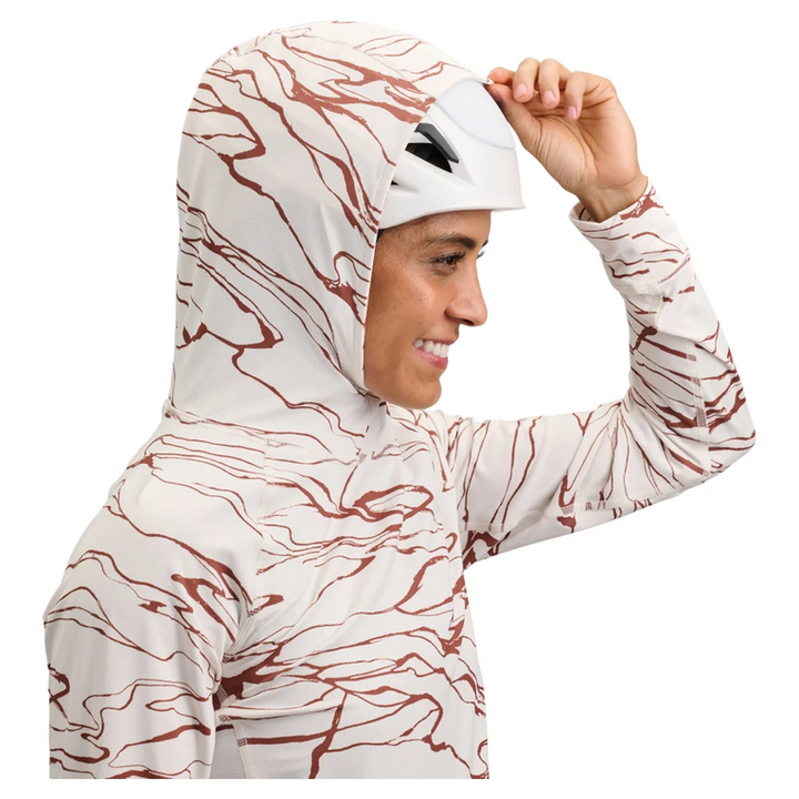 Person wearing a patterned hoodie and helmet on a white background