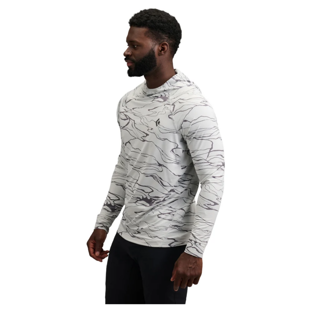 Man wearing a white hoodie with black abstract patterns on a white background
