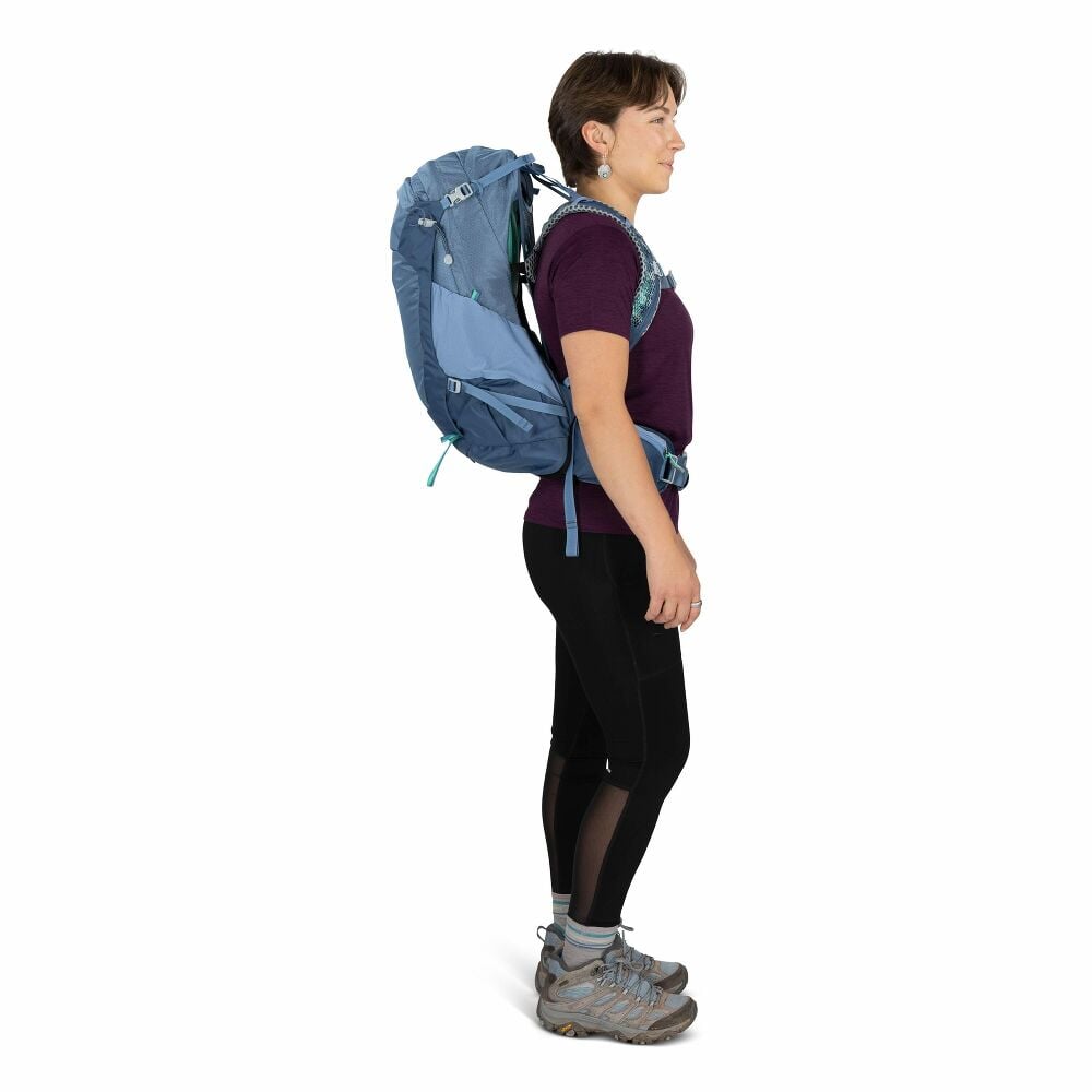 Person wearing a blue hiking backpack on a white background
