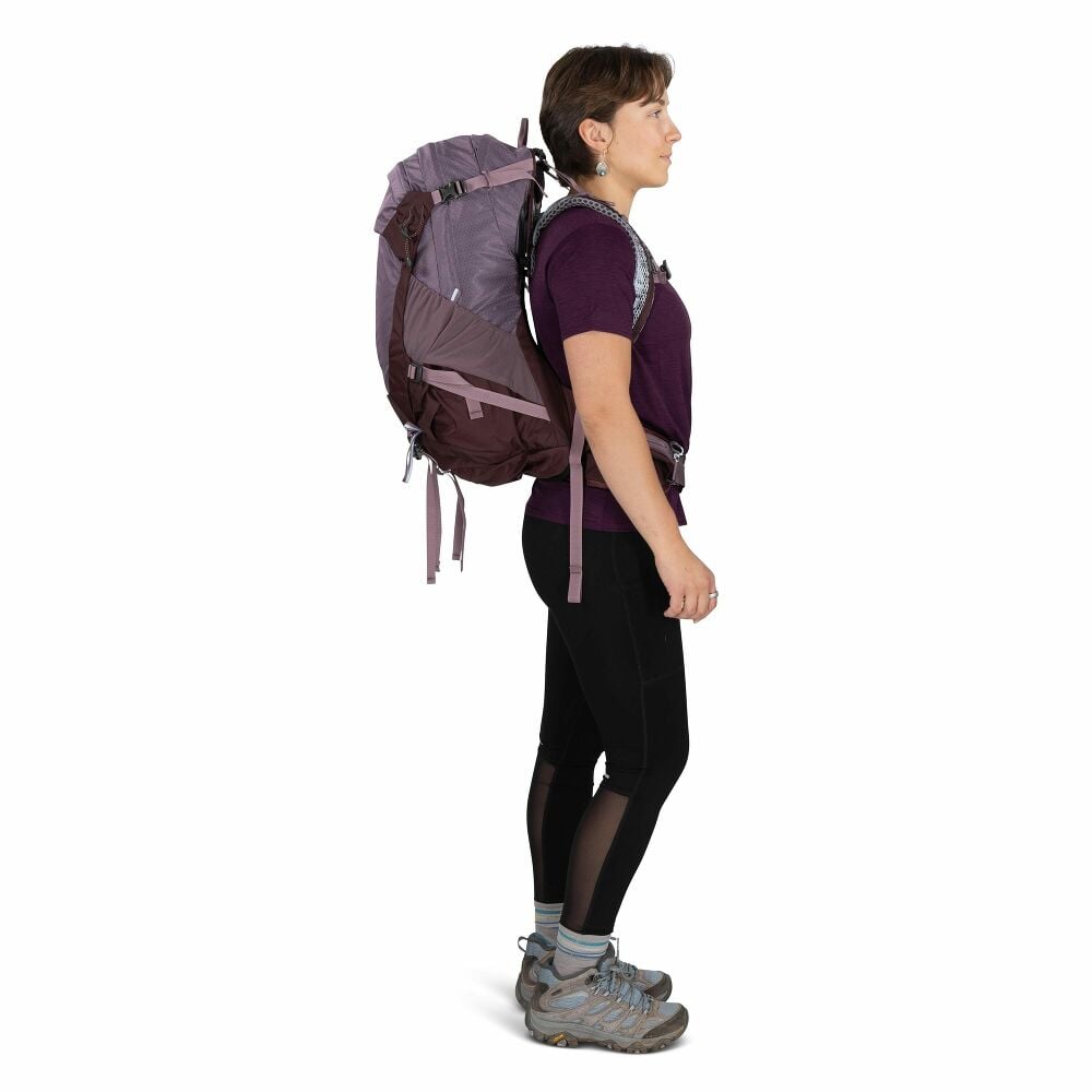 Person wearing a large purple backpack on a white background