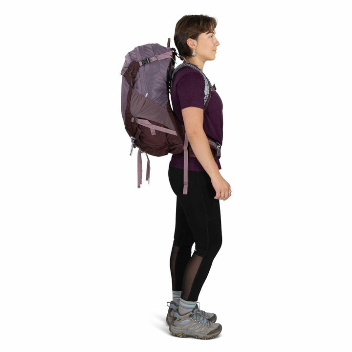 Person wearing a large purple backpack on a white background