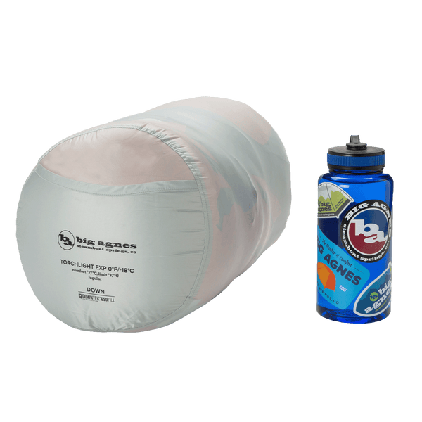 White sleeping bag stuff sack with Big Agnes branding next to 1L water bottle