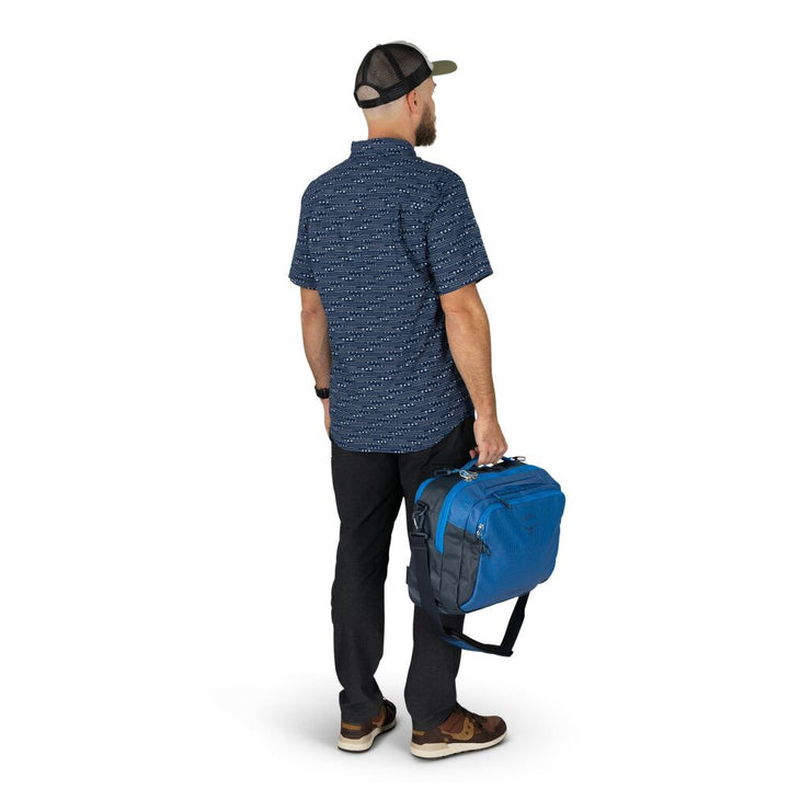 Man holding a blue duffel bag on a white background