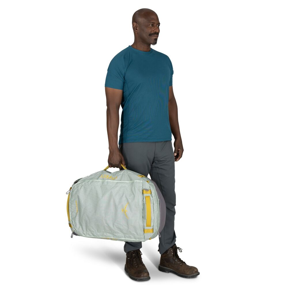 Man holding a light gray duffel bag with yellow accents on a white background