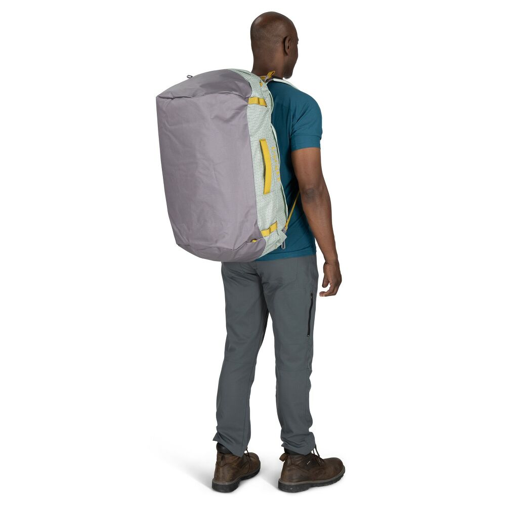 Person wearing a large gray backpack with yellow accents on a white background