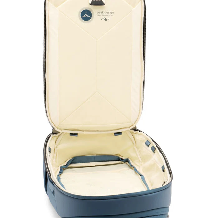 Open blue backpack with beige interior on a white background