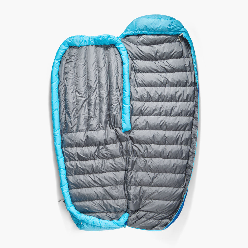 Blue sleeping bag fully unzipped and lying flat