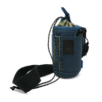 A blue drawstring pouch with a black adjustable strap and a black logo patch on the front, shown on a plain white background.