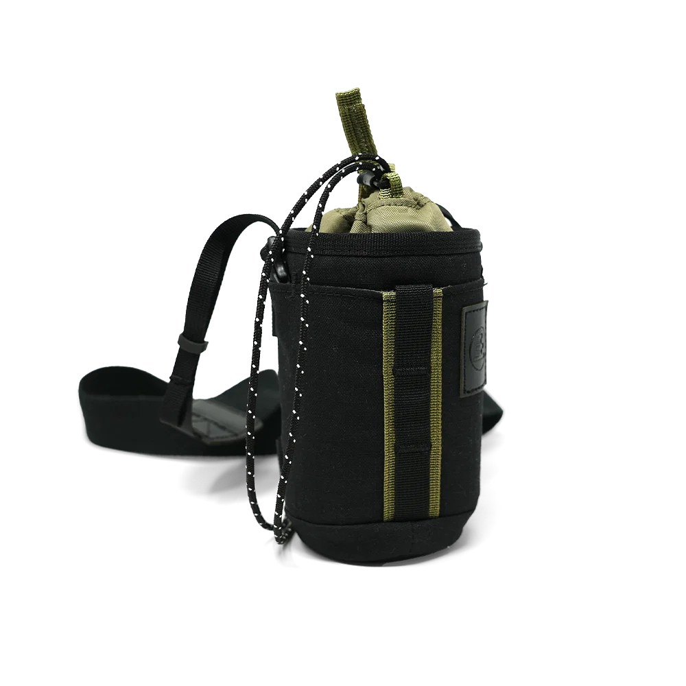 A black tactical bag with olive green accents, featuring a drawstring closure, a hanging chain, and a black strap, shown on a white background.