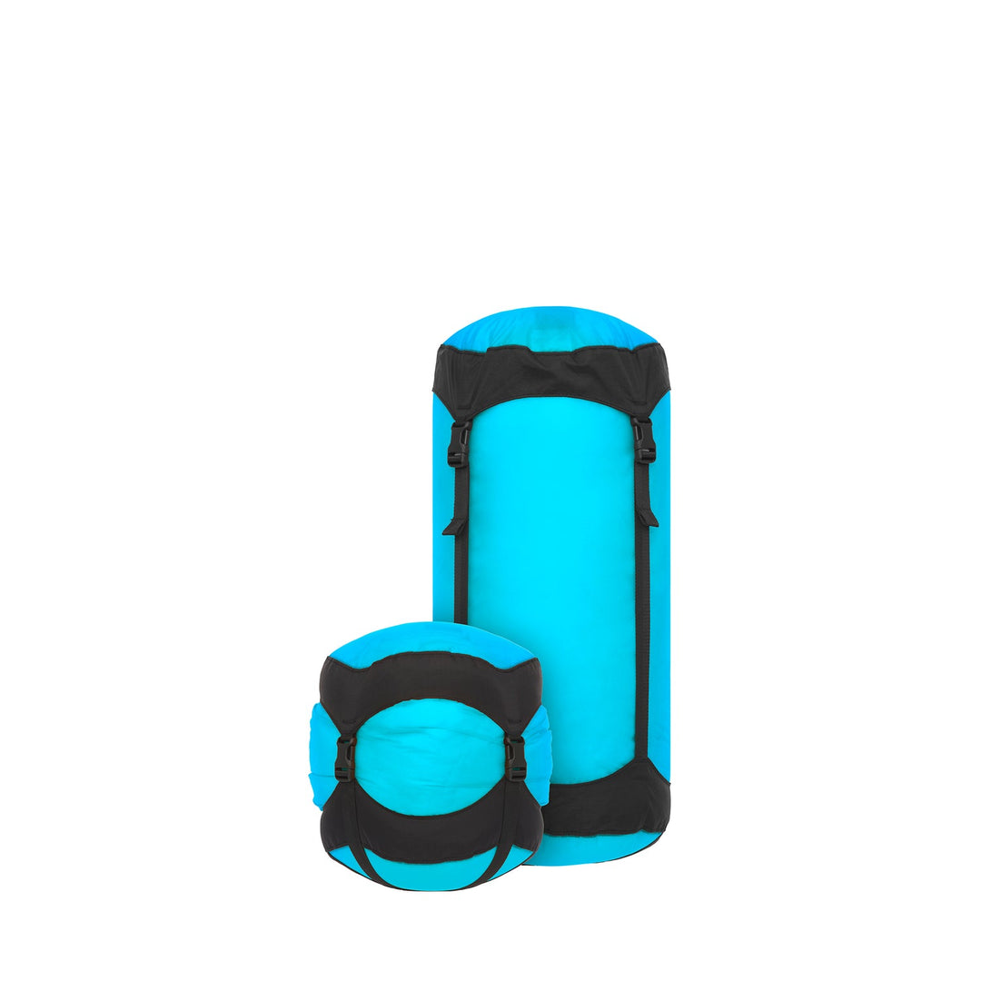 Two blue and black compression sacks on a white background