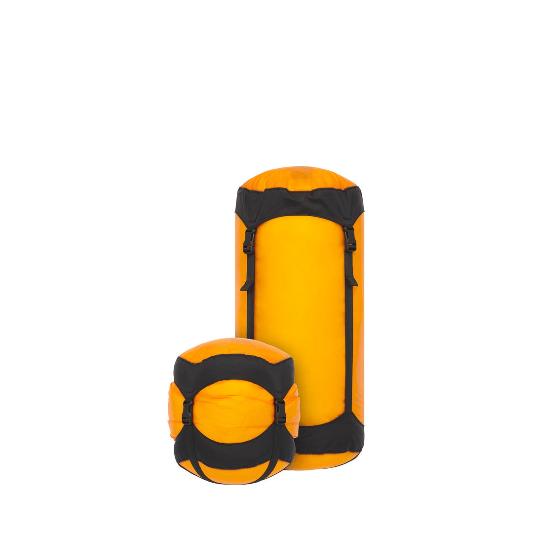 Two yellow and black compression sacks on a white background