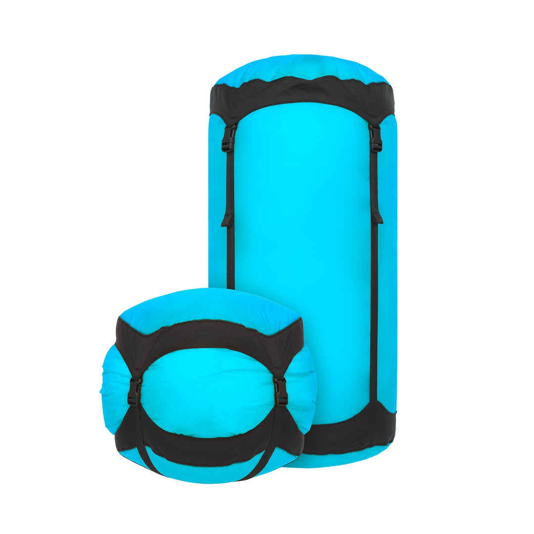 Two blue and black compression sacks on a white background