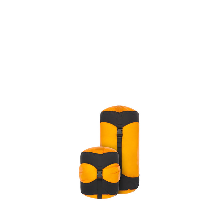 Two yellow and black compression sacks on a white background