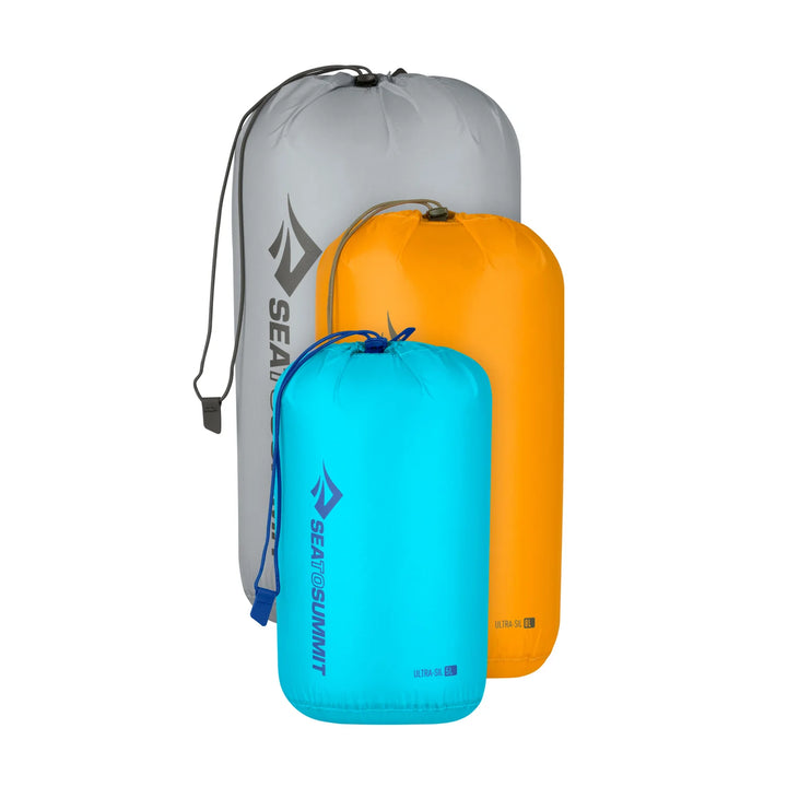 Three compression bags in gray, orange, and blue with Sea to Summit logo on a white background