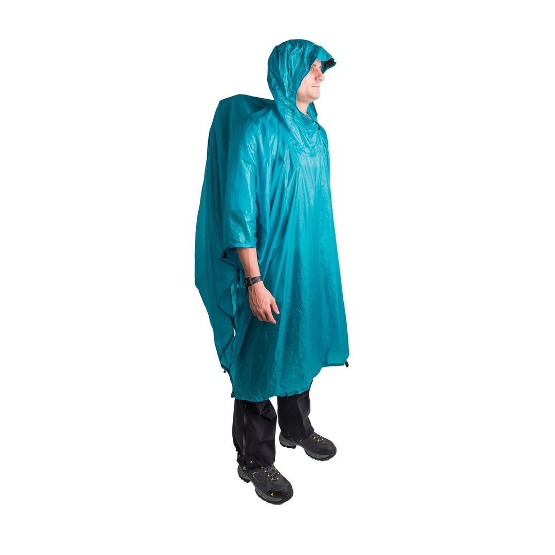 Person wearing a teal rain poncho over a large backpack