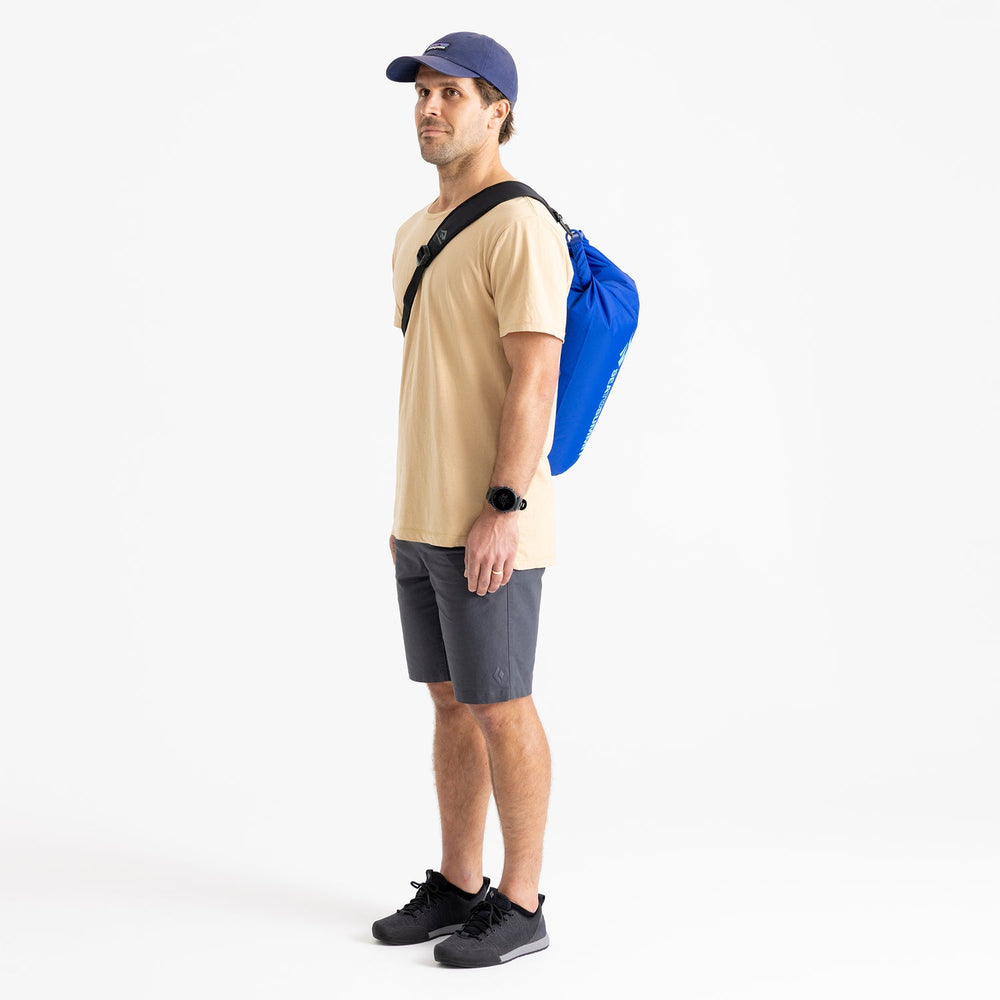 Man wearing a blue dry bag on a black shoulder strap