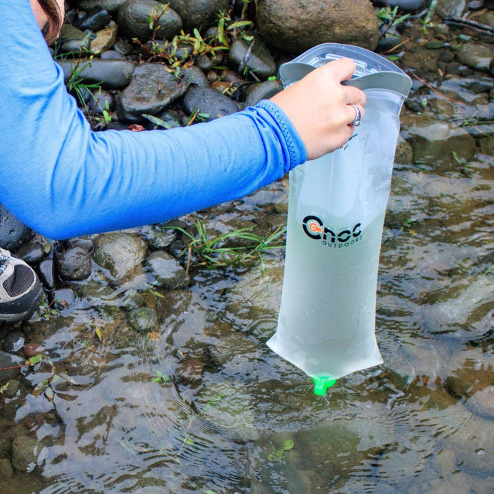 A Cnoc VectoX 28mm being used to collect water from a stream.