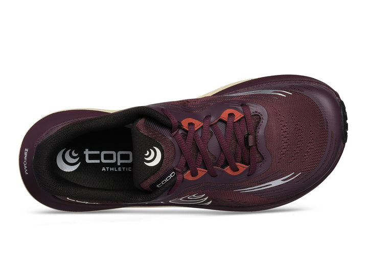 Maroon athletic shoe with orange laces on a white background