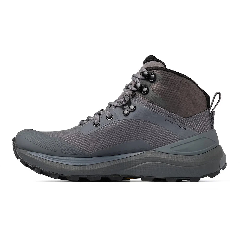 A mid-cut hiking boot in dark gray and black, featuring a lace-up design, mesh panels, and a rugged sole, shown from a side profile on a white background.