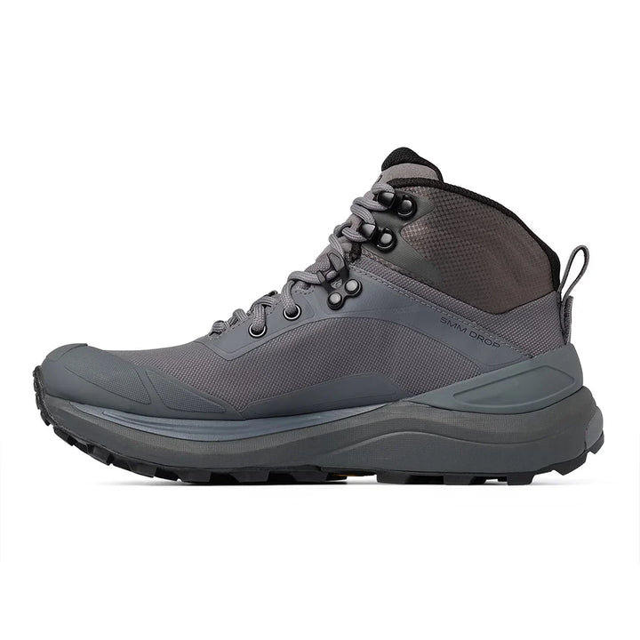 A mid-cut hiking boot in dark gray and black, featuring a lace-up design, mesh panels, and a rugged sole, shown from a side profile on a white background.