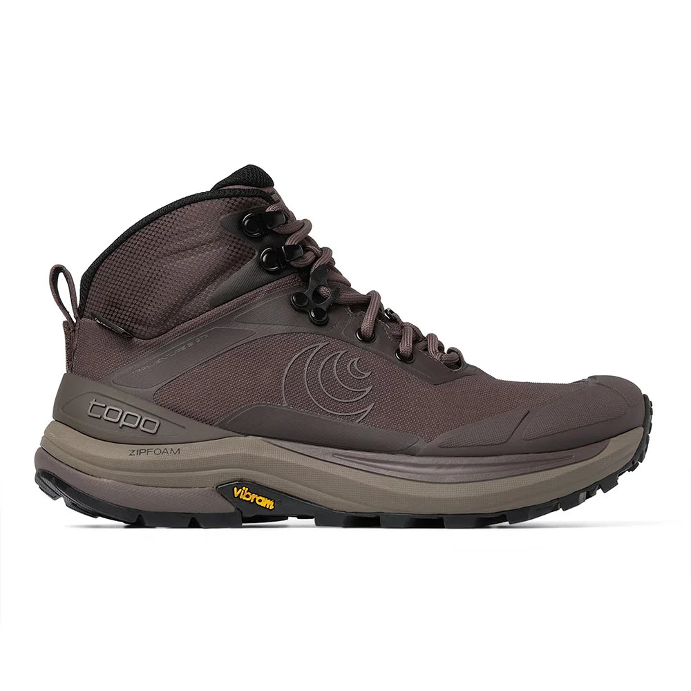 A single mid-cut hiking boot in dark brown and taupe with black laces and a rugged black outsole, shown from a side profile on a white background. The brand Topo is visible on the side and tongue.