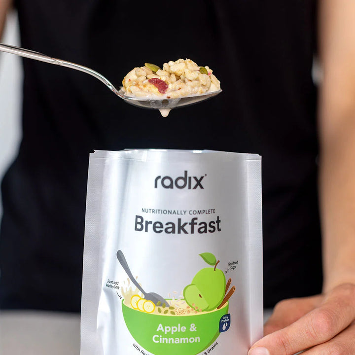 Spoonful of cereal over a package of radix breakfast mix with apple and cinnamon flavor.