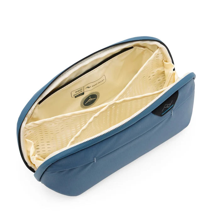 Blue toiletry bag with beige interior on a white background