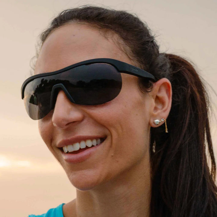 Woman wearing dark sunglasses with a blurred background