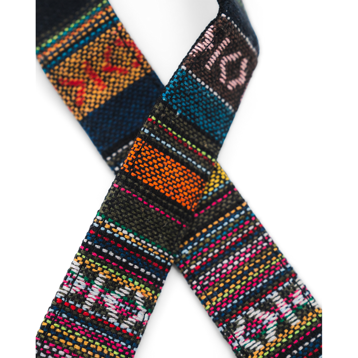 Close up a camera strap with a complex multicoloured design on a white background.