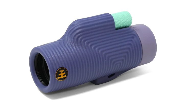 Purple monocular with a green dial on a white background