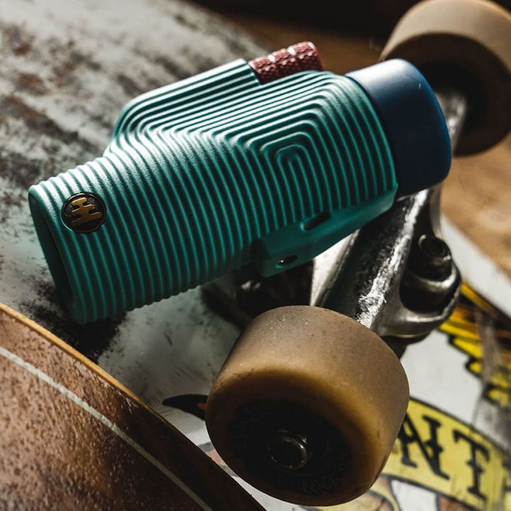 Close-up of a textured blue monocular lying on top of a skate board trucks