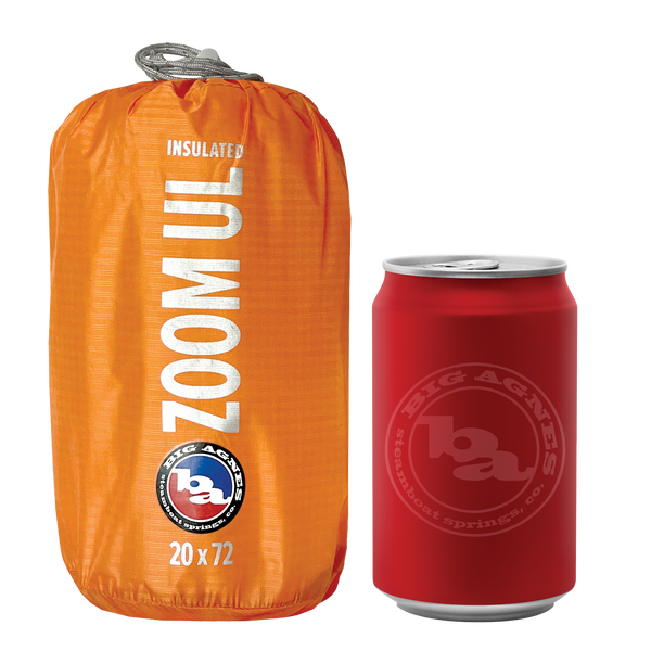 Orange sleeping mat stuff sack with Big Agnes branding and text reading "ZOOM UL" next to a soda can