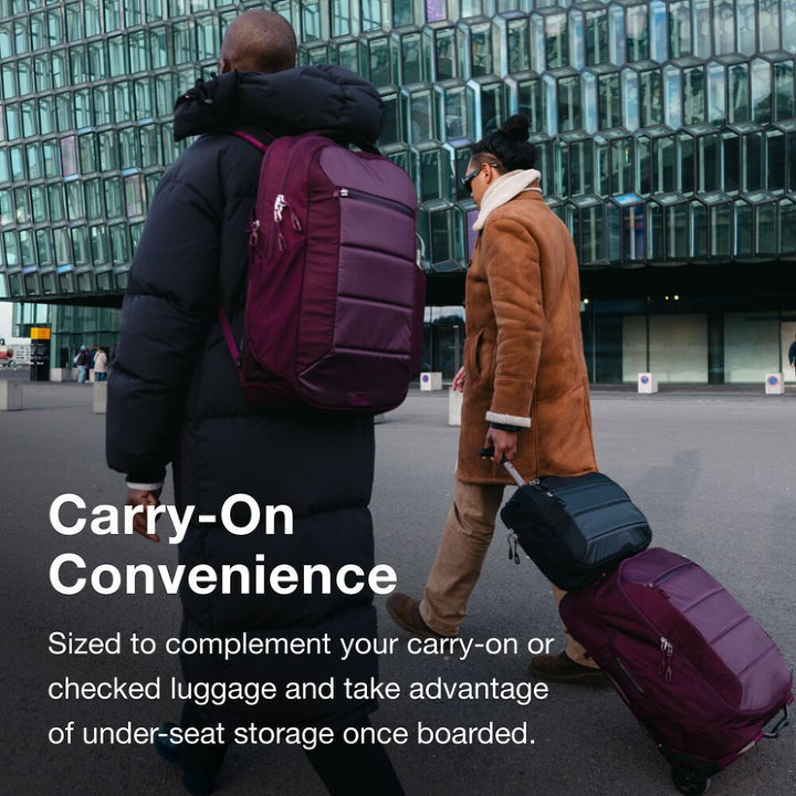 Two people with luggage walking in front of a modern building, with text about carry-on convenience.