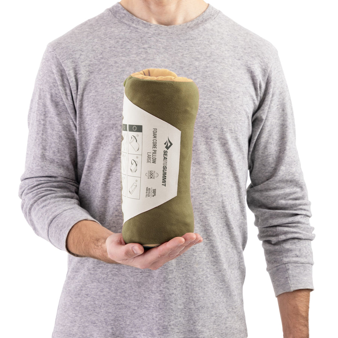 Peron holding up a rolled up pillow in paper Sea to Summit packaging
