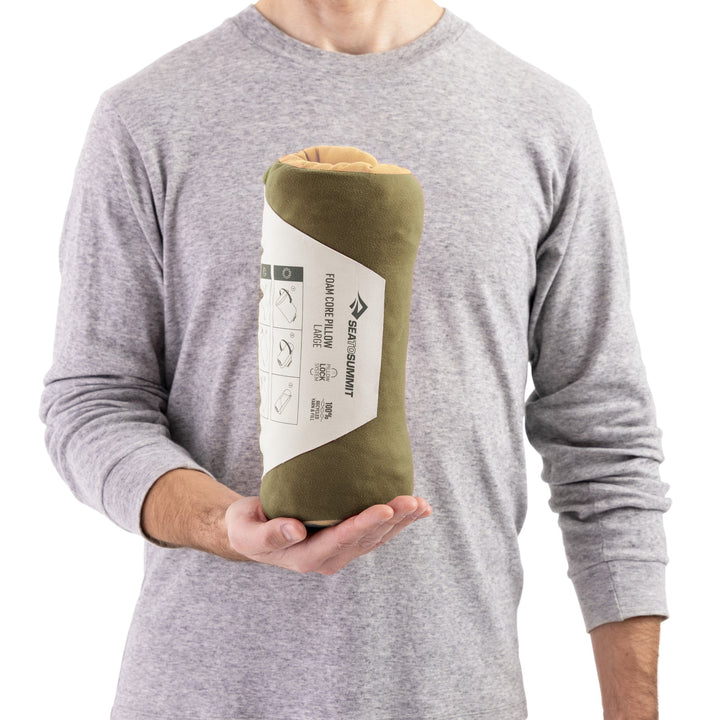 Peron holding up a rolled up pillow in paper Sea to Summit packaging