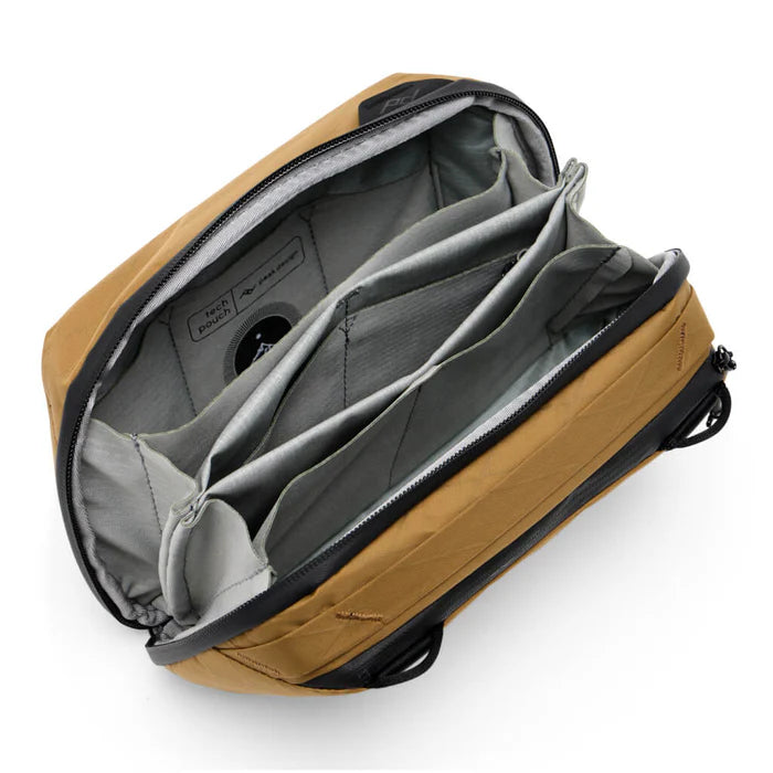 Open tan backpack with gray interior on a white background