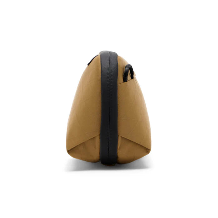 Side profile of tan accessory pouch on a white background