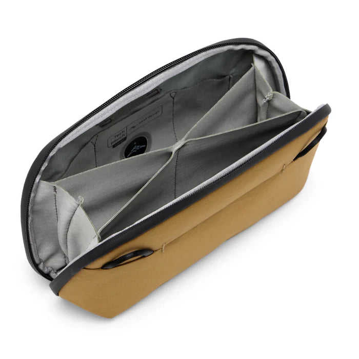 Inside of tan accessory pouch with grey interior and different pockets for organization on a white background