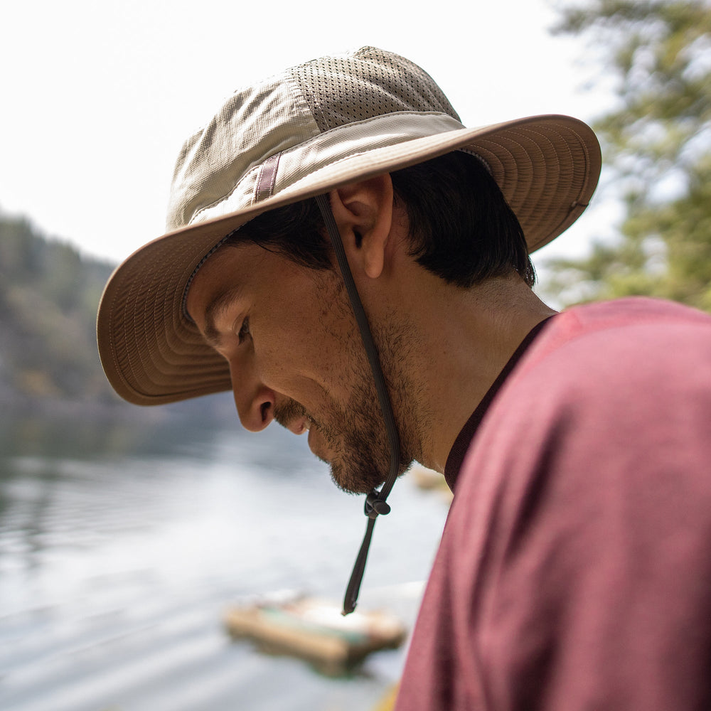 Man wearing a wide-brimmed hat by a lake