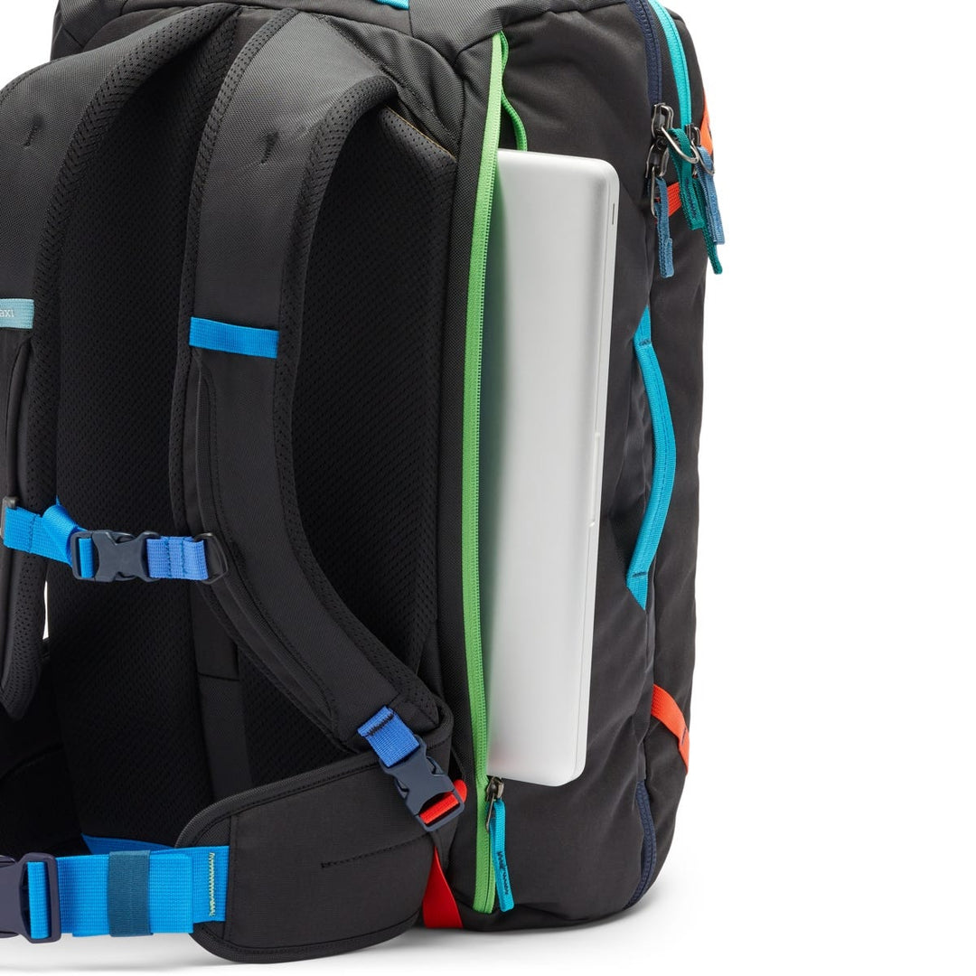 Lap top half inside a zipped laptop sleeve in a black backpack with colourful highlights