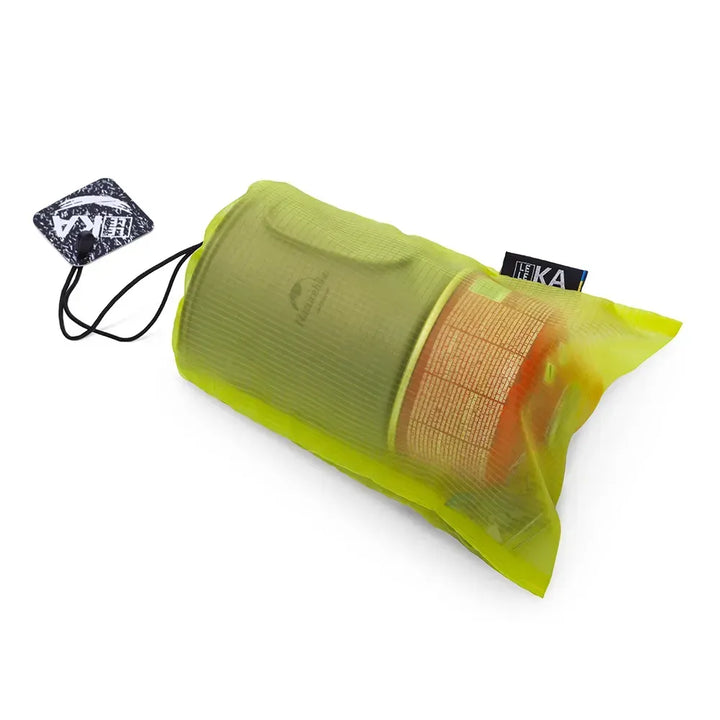 A translucent lime green bag with a drawstring closure, containing a cylindrical orange item, shown on a white background with two brand tags attached.