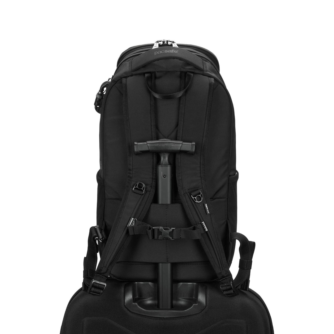 Black backpack strapped onto the extended handle of a suitcase