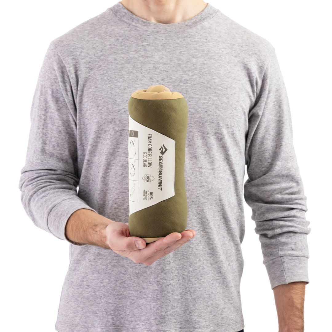 Peron holding up a rolled up pillow in paper Sea to Summit packaging