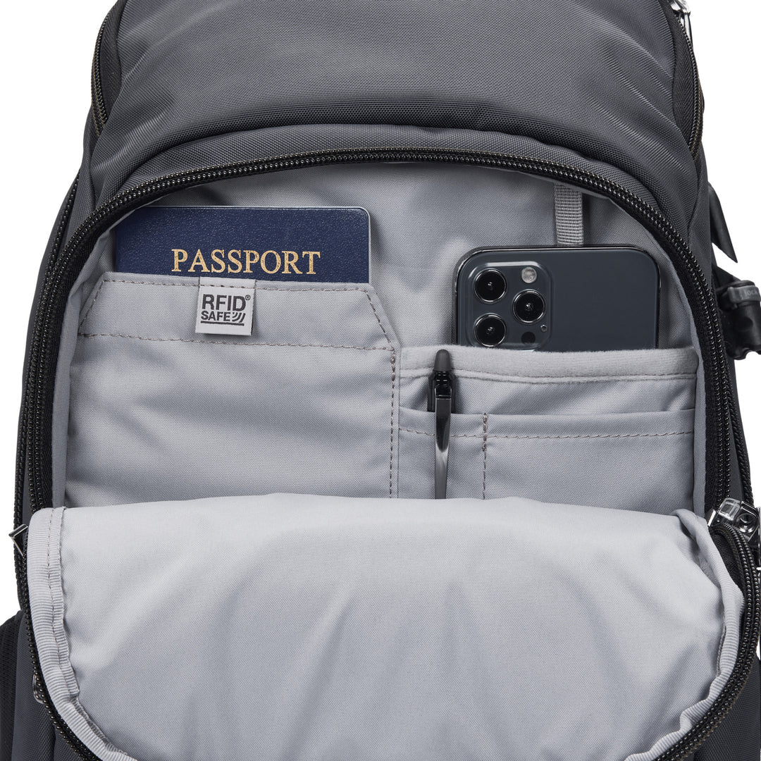 Gray backpack unzipped to show various organizational pockets storing a passport, phone, and pen.