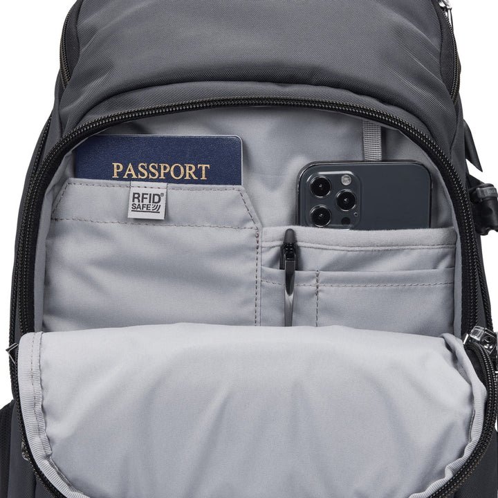 Gray backpack unzipped to show various organizational pockets storing a passport, phone, and pen.