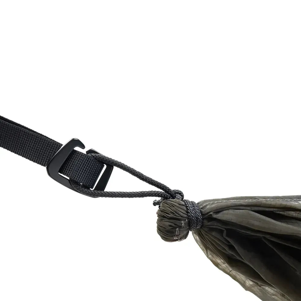 End of olive green hammock attached to strap on a white background. 