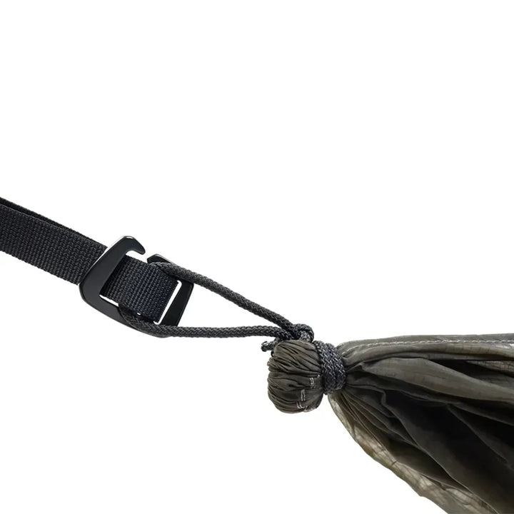 End of olive green hammock attached to strap on a white background. 