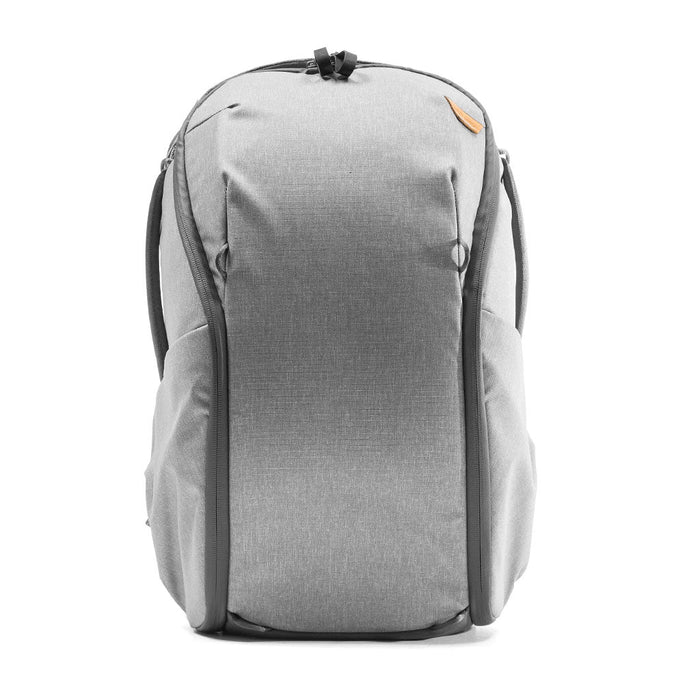 A light gray heathered backpack with black trim and a small orange accent tab, shown from the front on a white background.