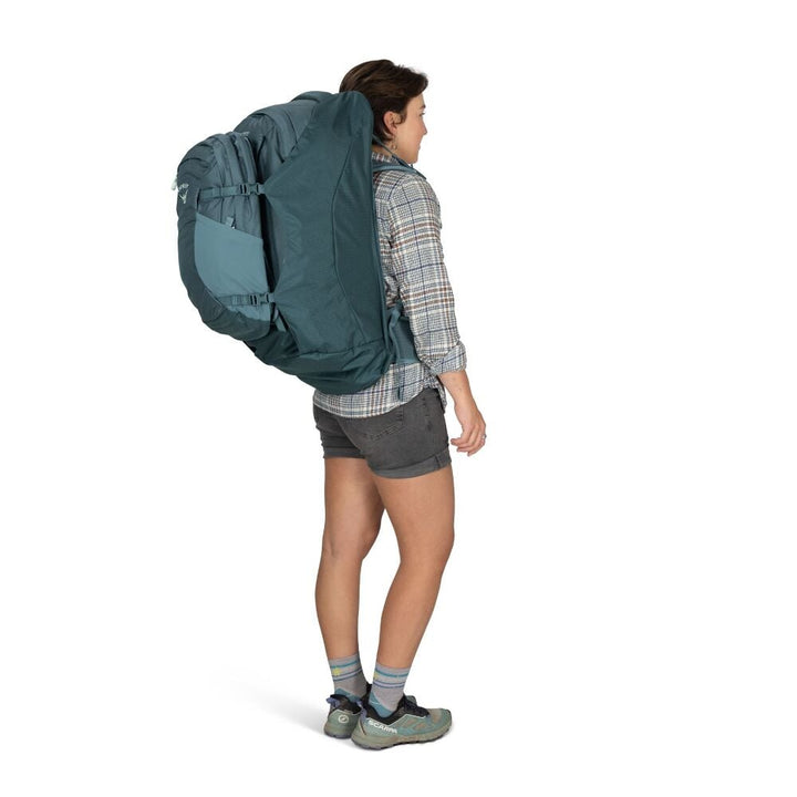 Person wearing a large blue backpack on a white background