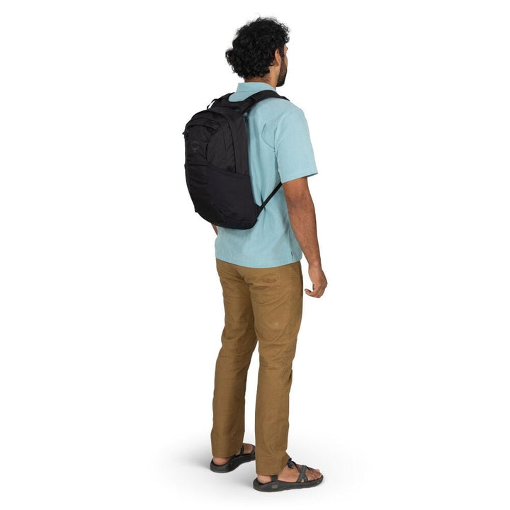 Man wearing a black backpack from behind on a white background